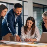 Business-Team in einem modernen Büro diskutiert vor einem Whiteboard mit Diagrammen und Notizen, symbolisch für analytisches und kritisches Denken im Beratungskontext