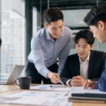 Professionelles Business-Bild mit einem selbstbewussten Berater, der konzentriert und gelassen an einem modernen Arbeitsplatz sitzt, umgeben von digitalen Tools und Notizen, die ein klares Kompetenzprofil symbolisieren