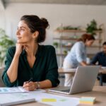 Professionelles Business-Beitragsbild: Eine junge Beraterin schaut neugierig durch eine Lupe auf ein komplexes Diagramm, im Hintergrund moderne Büroumgebung mit digitalen Displays