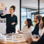 Professionelles Business-Beitragsbild mit abstrakter Darstellung von Technologie und Menschlichkeit, symbolisiert durch digitale Netzwerke und menschliche Hände