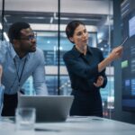 Professionelles Business-Beitragsbild: Zwei Consultants analysieren eine KI-Priorisierungsmatrix auf einem Whiteboard, um belastbare Use Cases auszuwählen
