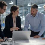 Professionelles Business-Bild: Ein junger Consultant erklärt einem Team an einem Whiteboard ein KI-Konzept, während eine abstrakte digitale Datenvisualisierung im Hintergrund die Verbindung von Technologie und Beratung symbolisiert
